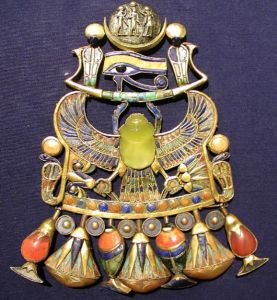 The central yellow scarab beetle in Tutankhamun's pectoral. The beetle is carved from Libyan desert glass, formed when a meteorite struck the sands of the desert.