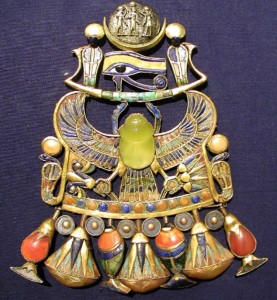 The central yellow scarab beetle in Tutankhamun's pectoral. The beetle is carved from Libyan desert glass, formed when a meteorite struck the sands of the desert.