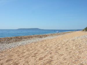 The Isle of Portland seen from Ringstead Bay on a sunny summer's day. To the right of the photo is Weymouth.